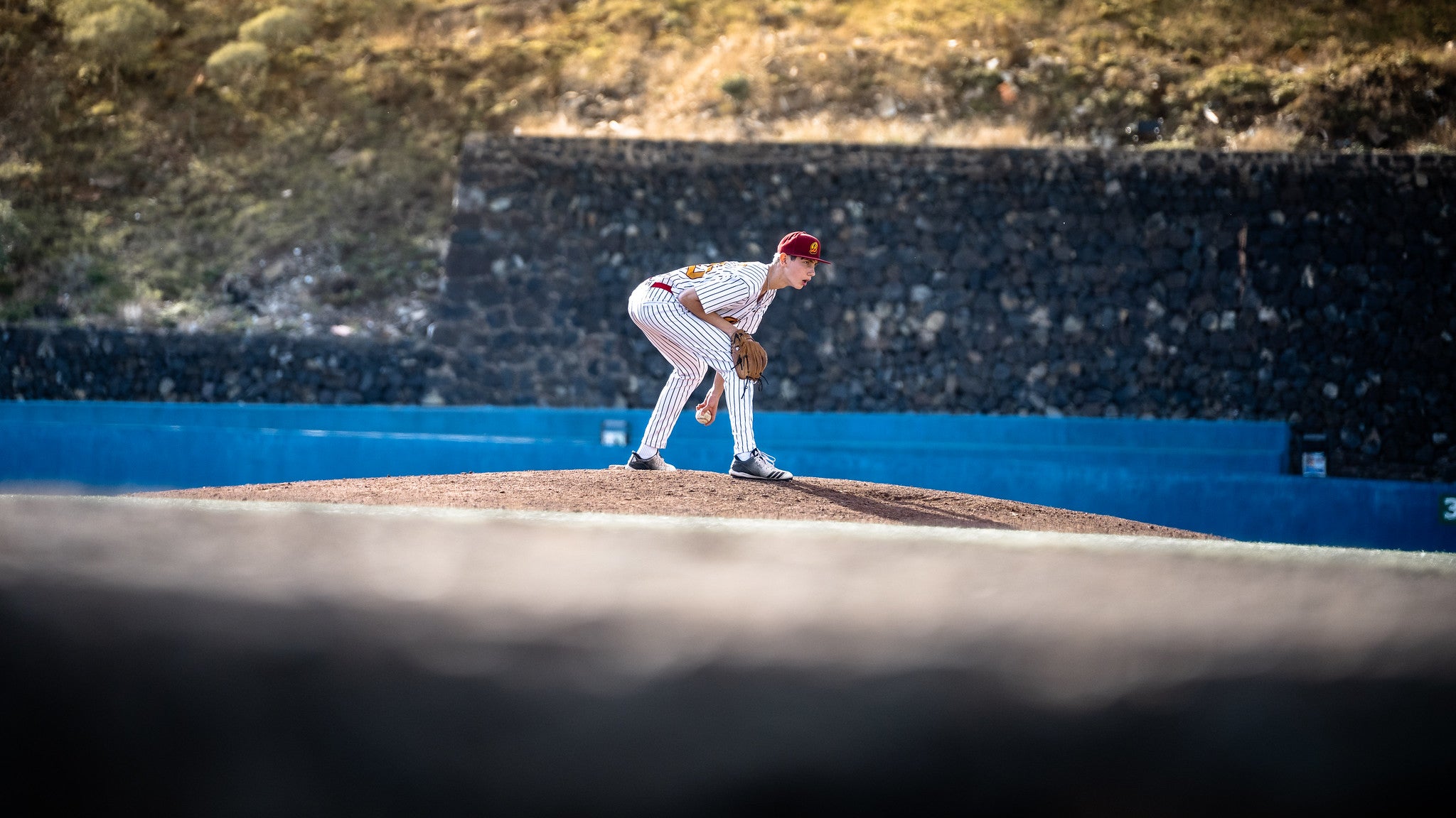 U15-Baseballspieler steht in defensiver Bereitschaftsposition auf dem Mound