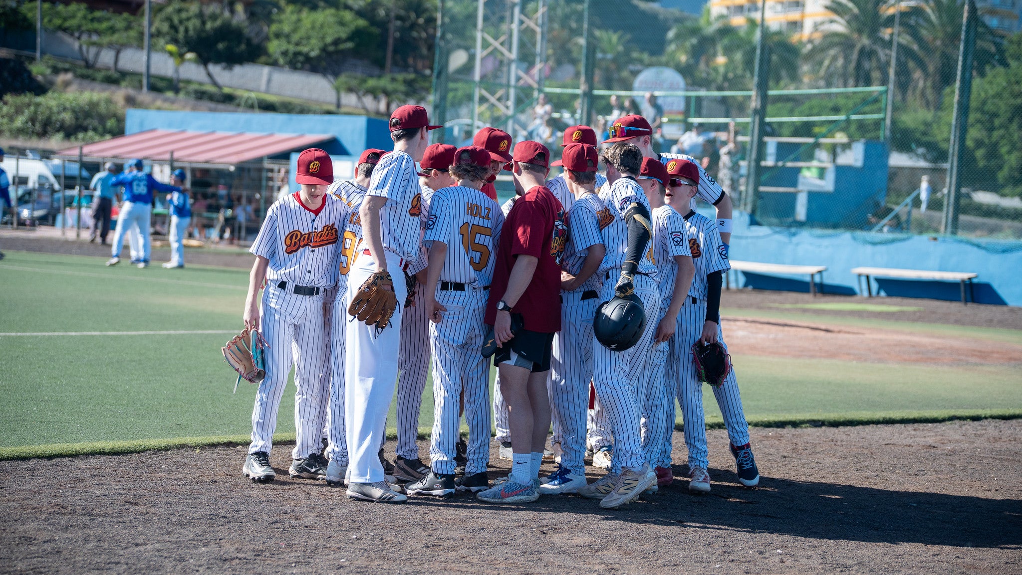 U15-Baseballmannschaft steht in einer Gruppe zur Besprechung während des Spiels