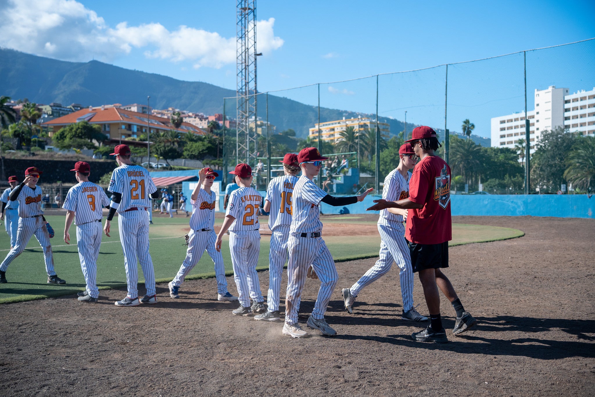 U15-Baseballspieler geben sich nach dem Spiel auf dem Feld gegenseitig High Fives